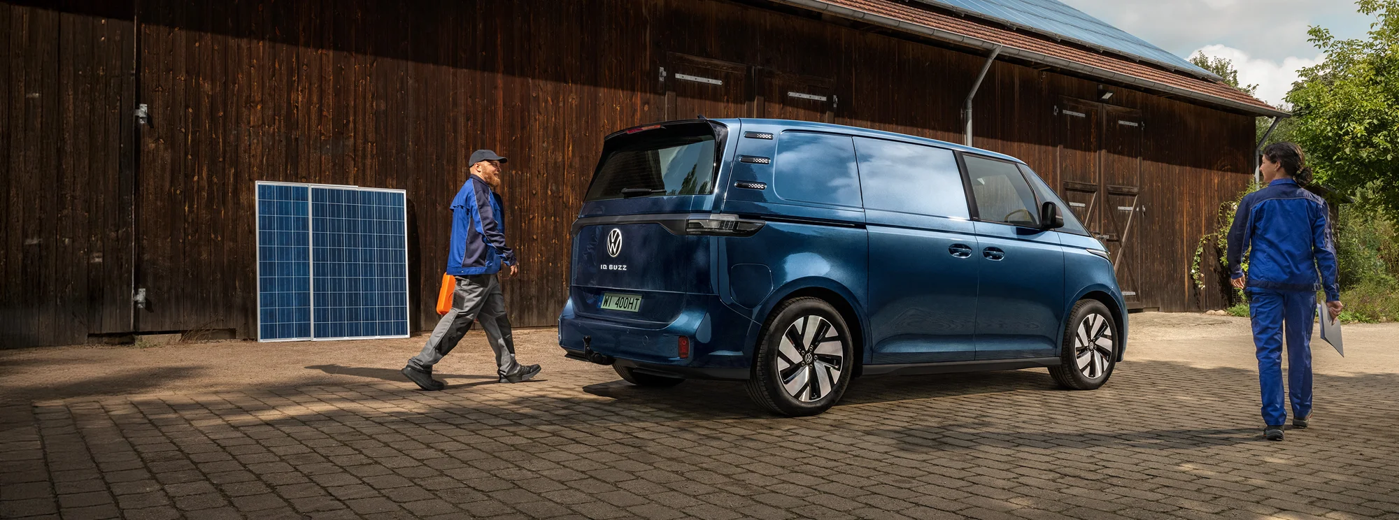 dostawczy samochód elektryczny Volkswagen ID. Buzz w wersji Cargo stojący obok stodoły