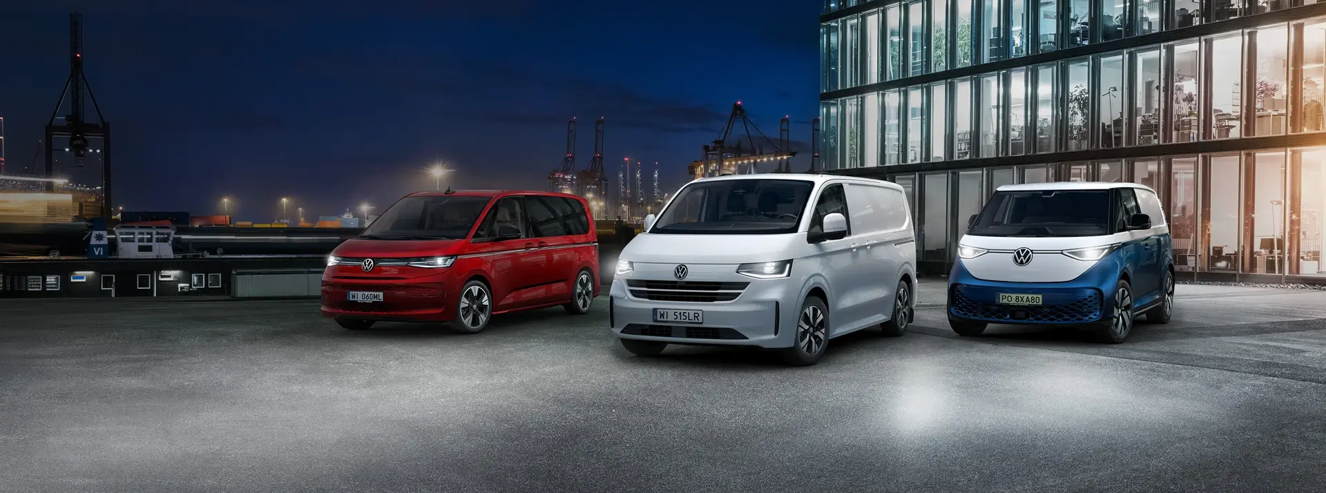 trzy Volkswageny dostawcze na dachu nowoczesnego budynku, czerwony Caddy, biały Transporter i białoniebieski ID. Buzz